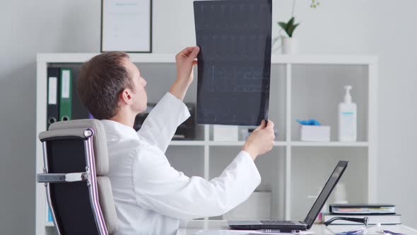 Professional medical doctor working in hospital office using computer technology.