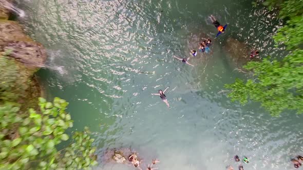 Aerial view of woman swimming in pool by Kawasan Falls in Alegria, Philippines.