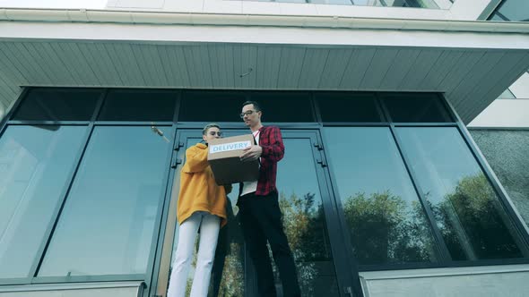 Male Courier Delivers a Package To a Woman