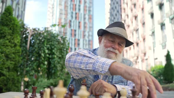 Zoom Out Peaceful Old Aged Man Playing Chess Alone