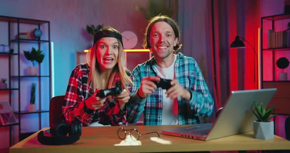 Couple Having Fun Together at Gaming at Home and Celebrating Victory greeting