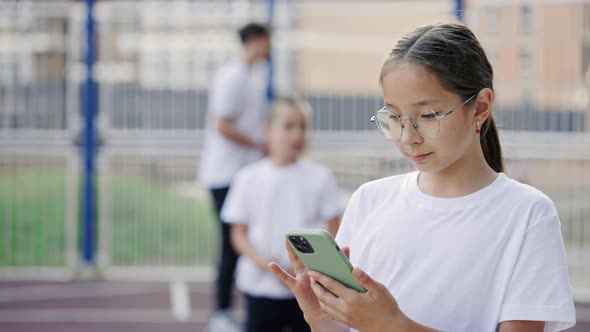 Cute Primary School Girl Using Smartphone