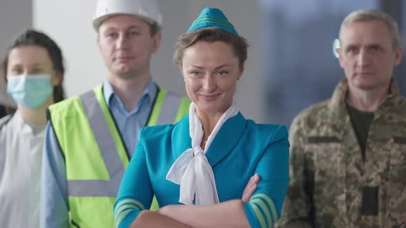 Slim Confident Beautiful Woman in Stewardess Uniform Crossing Hands Looking Away with People of