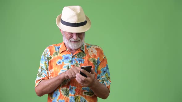 Handsome Senior Bearded Tourist Man Ready for Vacation Against Green Background