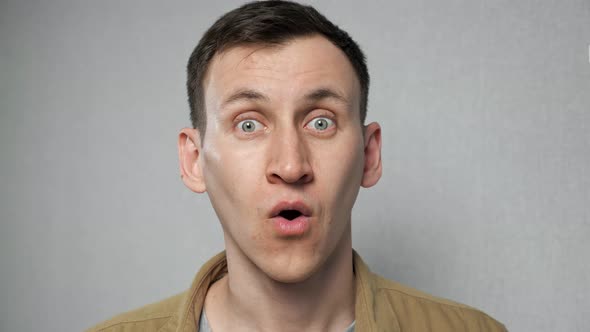 Emotional Male Person Shows Astonishment on Grey Background