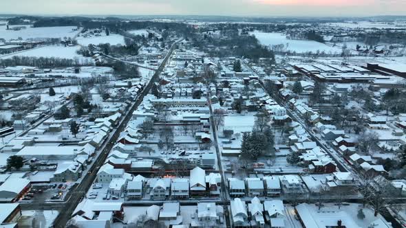 American town covered in snow at Christmas. Snow flurries and snowflakes during aerial truck shot.