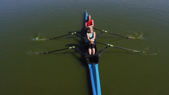 Senior caucasian man and woman rowing boat on a river