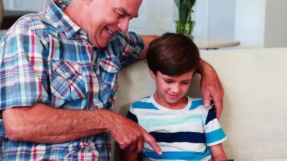 Happy father and son using laptop in living room