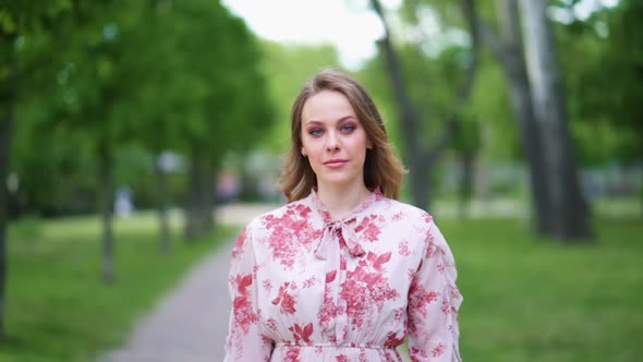 Attractive Young Woman with Smoky Eyes Make Up Look at Camera Smile Stand in the City Park Slow