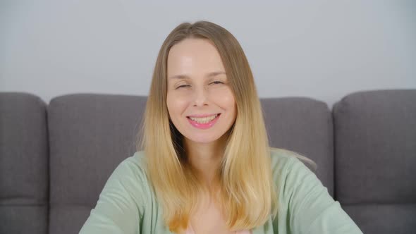 Cheerful blonde woman looking in camera with friendly toothy smile in 4k video