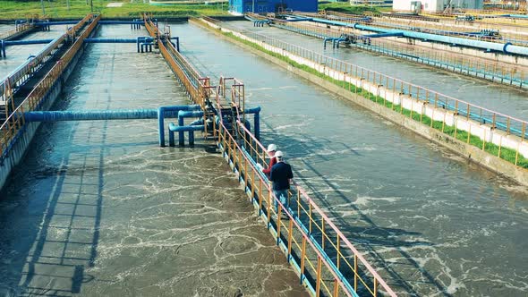 Two Businessmen Walking Through a Large Wastewater Cleaning Facility