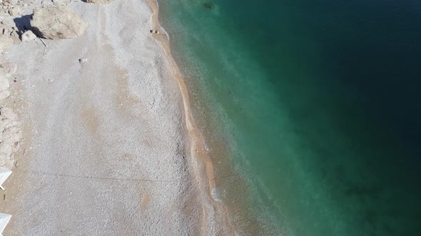 Aerial View From Above on Azure Sea and Pink Pebbles Beach