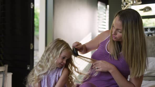 Mother brushing the hair on her daughter