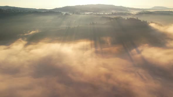 4K Aerial view flying in fog. clouds at sunset fog.