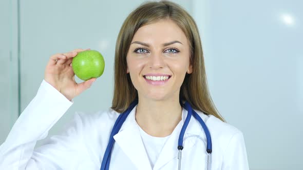 Close Up of Female Doctor Holding Green Apple in Hand