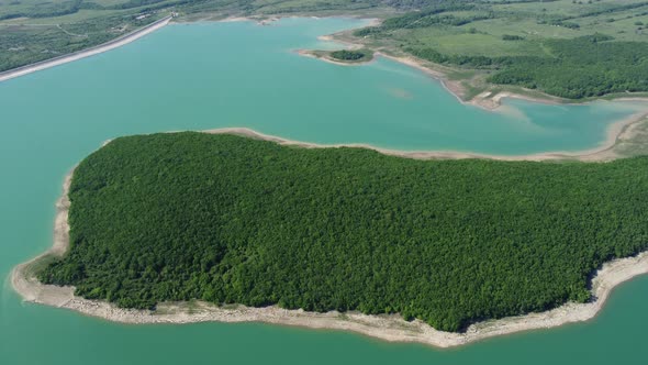 Aerial View on Water Reservoir at Mountain Valley Covered with Green Spring Forest