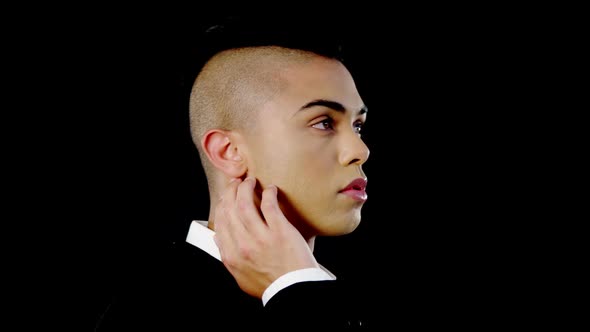 Androgynous man posing against black background