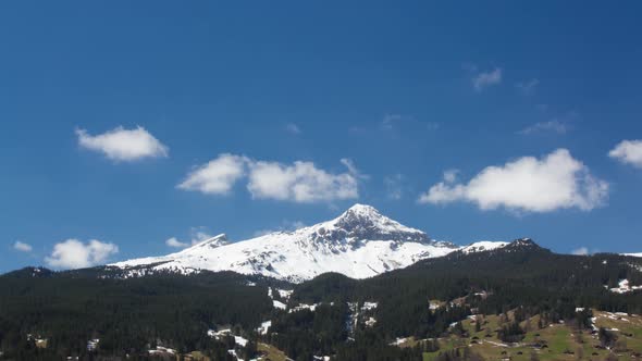 Timelapse of cumulus clouds over snowy mountain top in Grindelwald Switzerland.