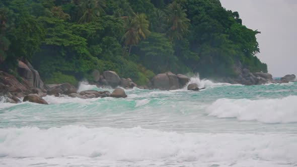 waves scatter around the rocks on the island, slow motion