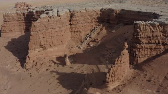 Aerial view of sandstone rock formed cliffs with a bizarre formations and a hoodoo is seen in the so