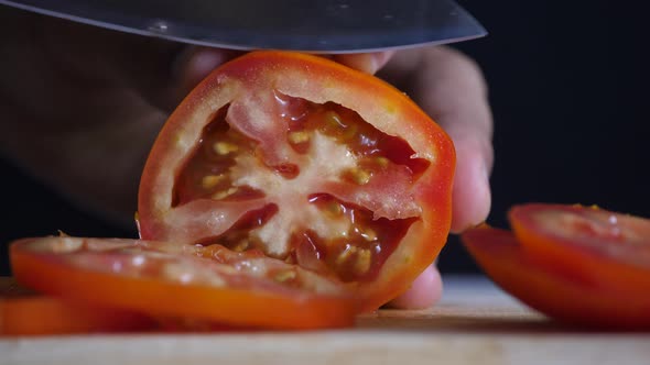 Chef slices ripe tomatoes for cooking