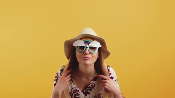 Young Blonde Woman Wearing Sun Hat and Rainbow Glasses Checking Herself Out in Camera Flipping Her