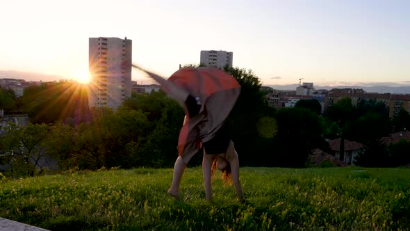 Young woman turning wheels at viewpoint during sunset