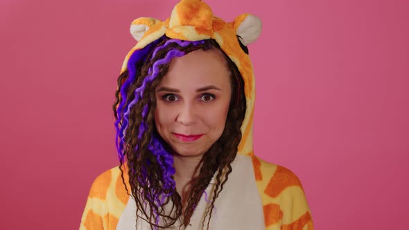 Young Shy Beautiful Woman in Kigurumi Looking at Camera on Pink Background