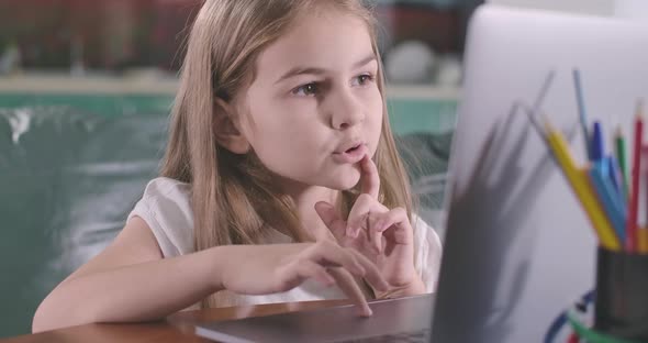 Close-up Face of Caucasian Girl Looking at Laptop Screen and Using Touchpad. Education, E-learning