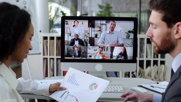 Two Business Colleagues of Different Nationalities Talking on Video Call with Colleagues