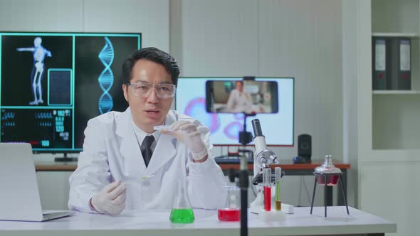 Man Taking Test Tube With Micropipette Putting In Petri Dish And Using Smartphone Recording Video