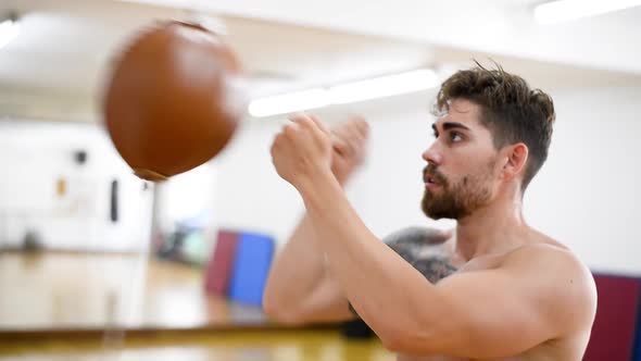 Young male boxer at the gym hitting the punching ball