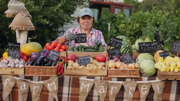 Senior Woman Farmer Prepares the Grocery Counter at the Farmers Market