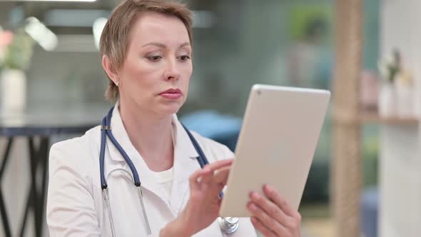 Professional Middle Aged Female Doctor Using Tablet