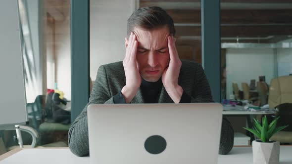 Depressed Young Business Man Suffering From Head Ache Having Painful Head Feelings Due To Computer