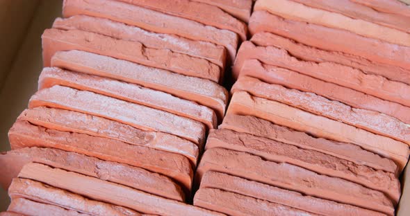 Worker Puts Brick Cast with Pattern on Rows of Blocks in Box