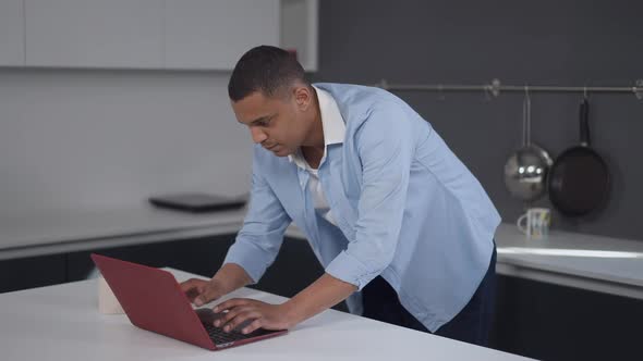 Focused African American Young Man Surfing Internet Scratching Head Thinking