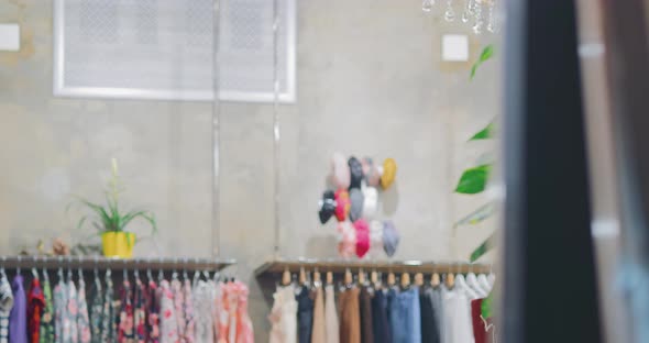 Nice Girl Trying on Clothes in Front of a Large Mirror in a Store Fashionable Clothing Boutique