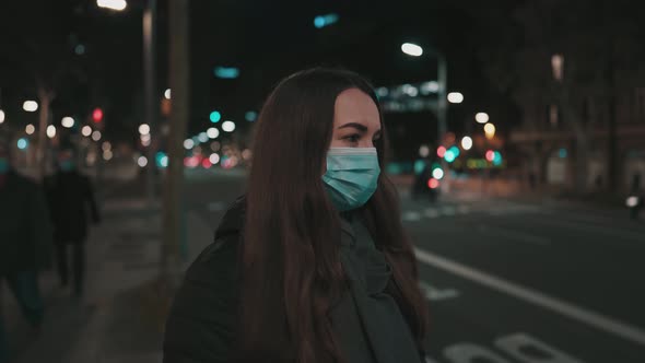 Female Model Wearing Mask Against Virus Walking Alone in the Night City