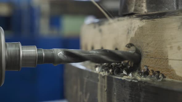 Shavings Flying Out from Huge Drill is Boring a Hole in the Metal Turbine Piece