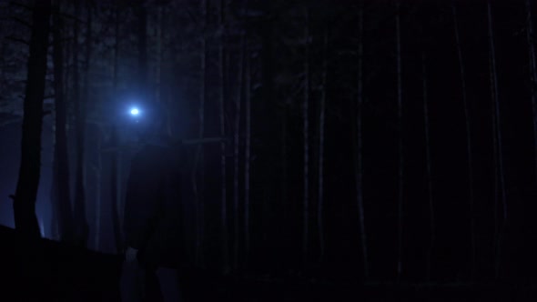 Man walking in the forest in the dark.