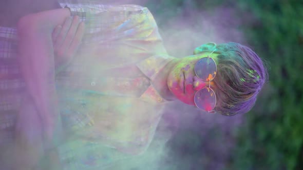 Vertical Video. Portrait of Boy Standing Being Covered in Coloured Powder at Holi Festival