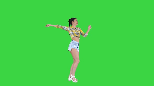 Magnificent Sweet Girl in Jeans Shorts, Sneakers, Dancing on a Green Screen, Chroma Key