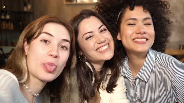 POV of Three Multiethnic Young Women Making a Selfie in a Coffee Shop