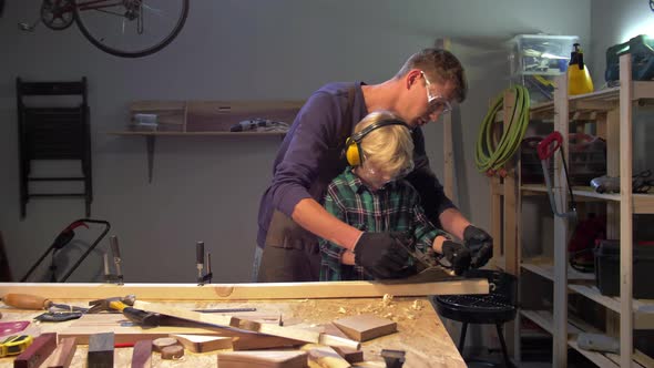 Master Teaches Little Boy To Polish Wood Board