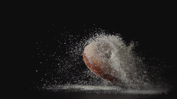 Donut With A Sugar Powder Falls On A Black Desk