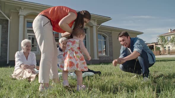 Toddler Learning to Walk with Supportive Family alt