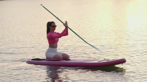 Fitness Woman Practising in Paddle Boarding During Sunset