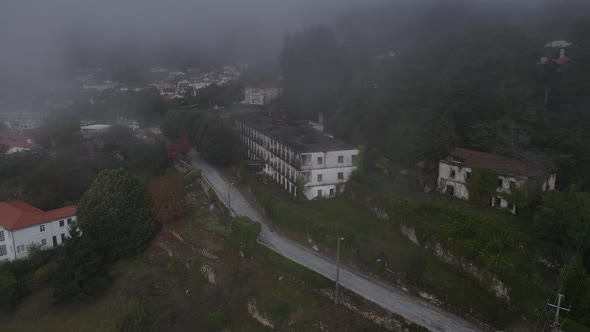 Aerial drone view over Caramulo Sanatorium old abandoned building on misty day, Portugal