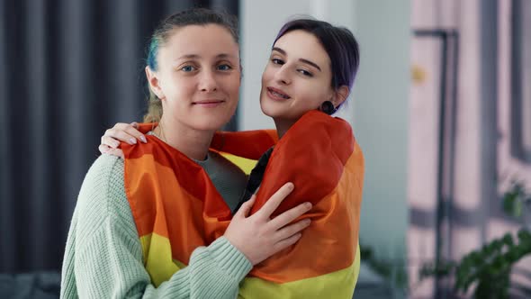 Beautiful Women Wrapped in Colorful Rainbow Flag at Home